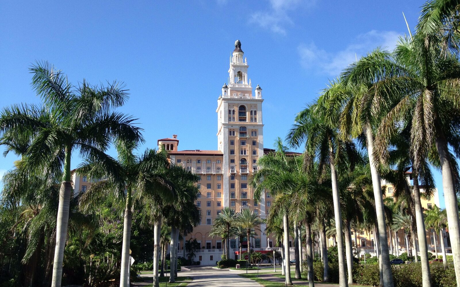 The tower of the Biltmore Hotel in Coral Gables at the end of a drive lined with palms